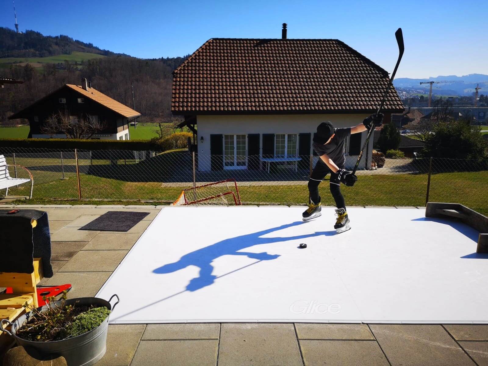 You guy practicing stick handling on a small backyard ice rink in summer