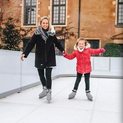 Mother and daughter skate on synthetic ice rink