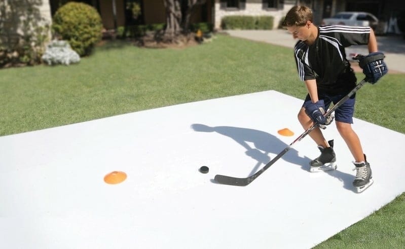 Boy playing ice hockey in backyard