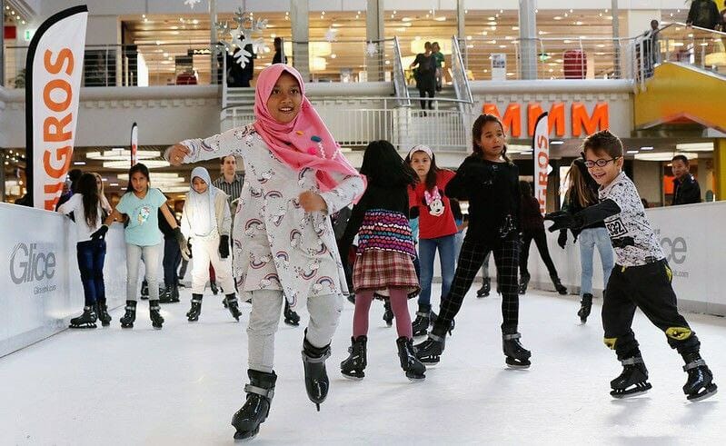 Kids happily skating on synthetic ice